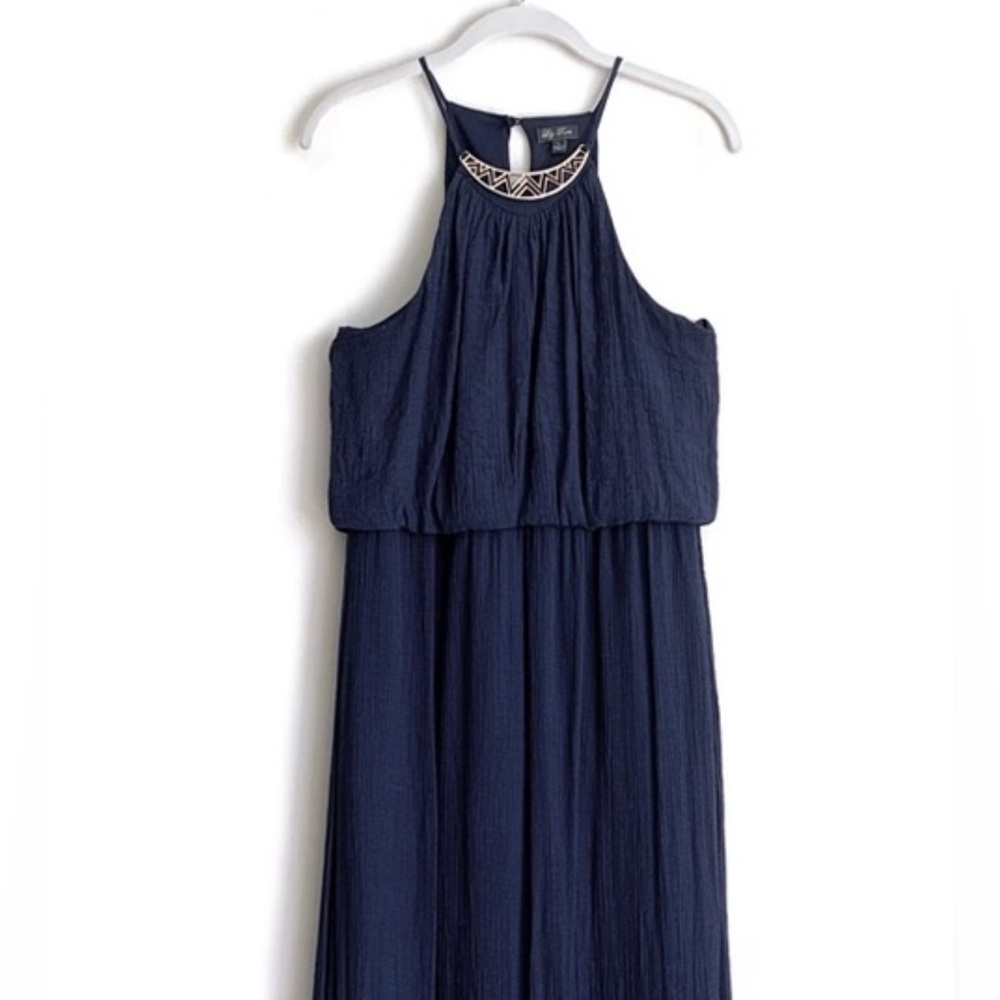 dark blue, sleeveless dress with a gold geometric necklace neckline